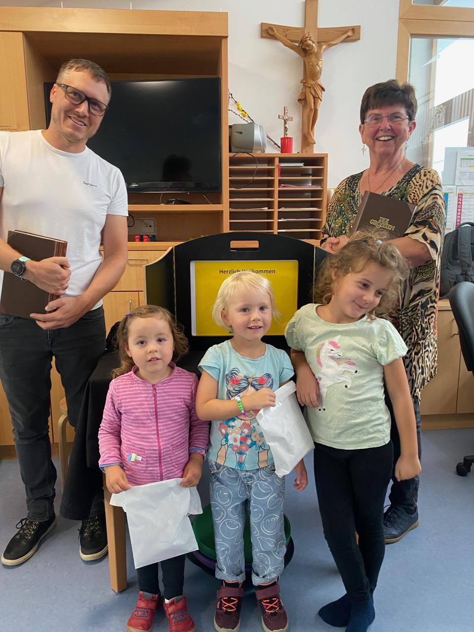Zwei Erwachsene Vorleser und drei Kinder sind am Bild
