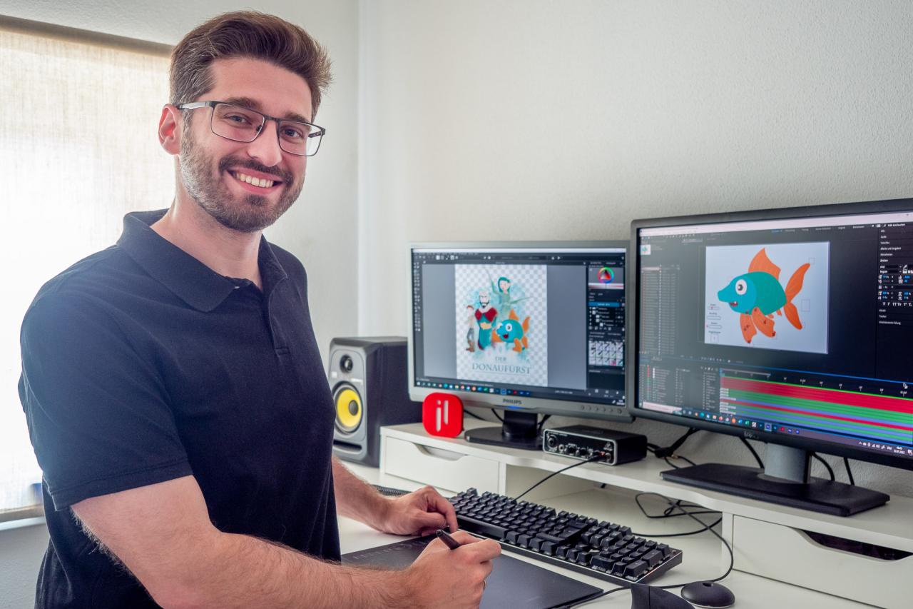 Ein Mann steht vor zwei Bildschirmen