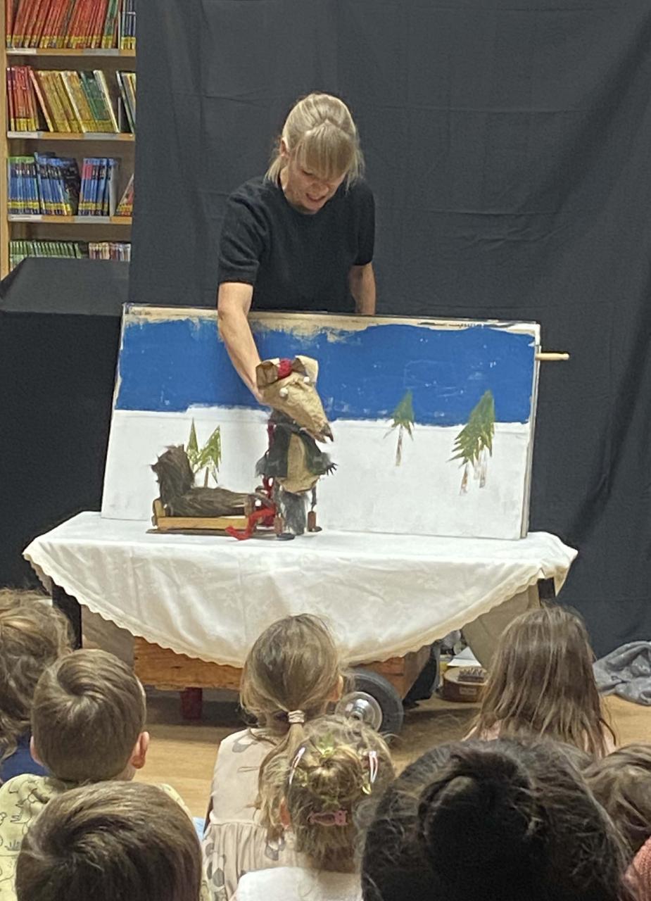 Eine Frau erzählt mit einer Wolfspuppe die Geschichte