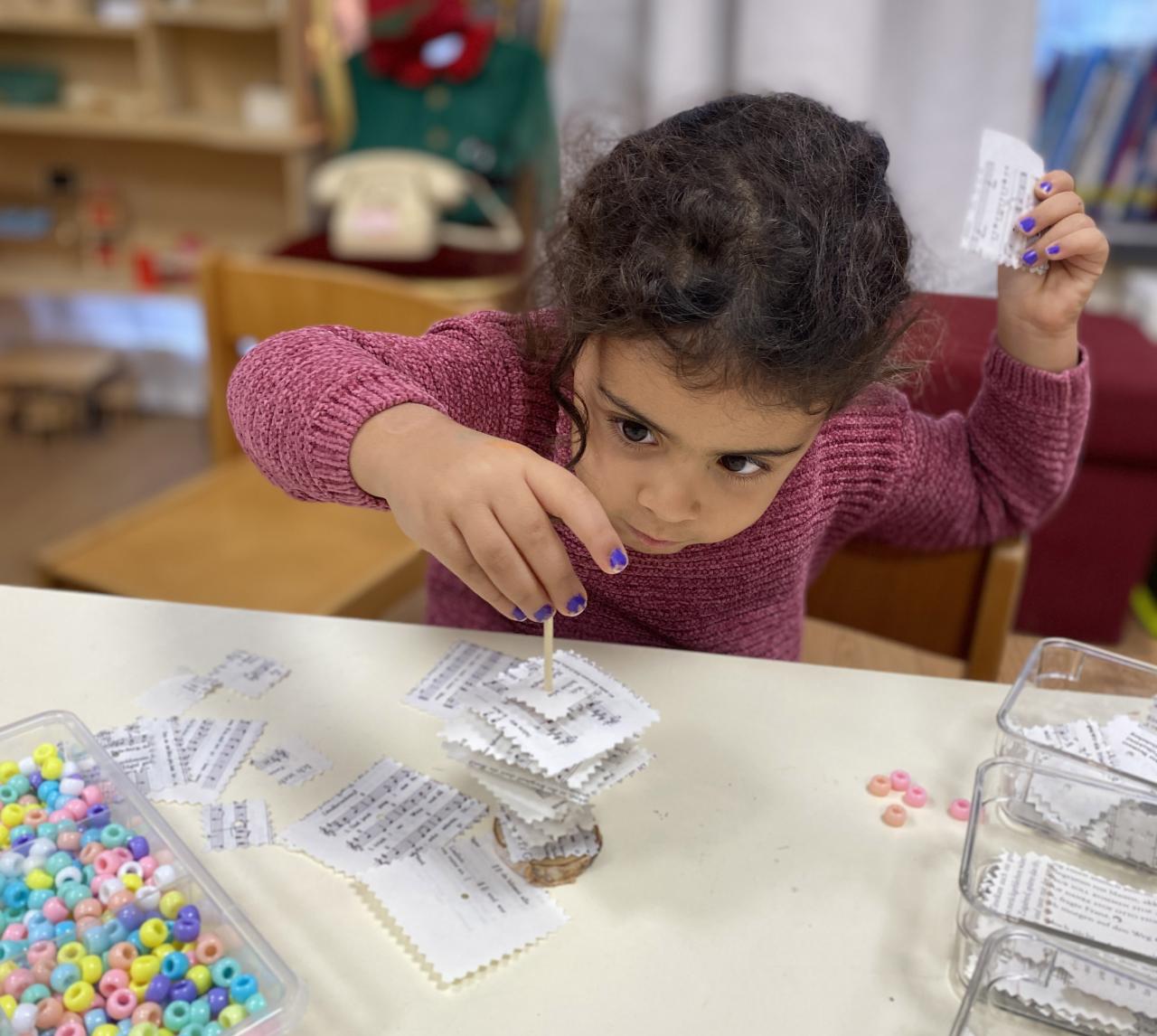 Ein Mädchen bastelt mit alten Buchseiten