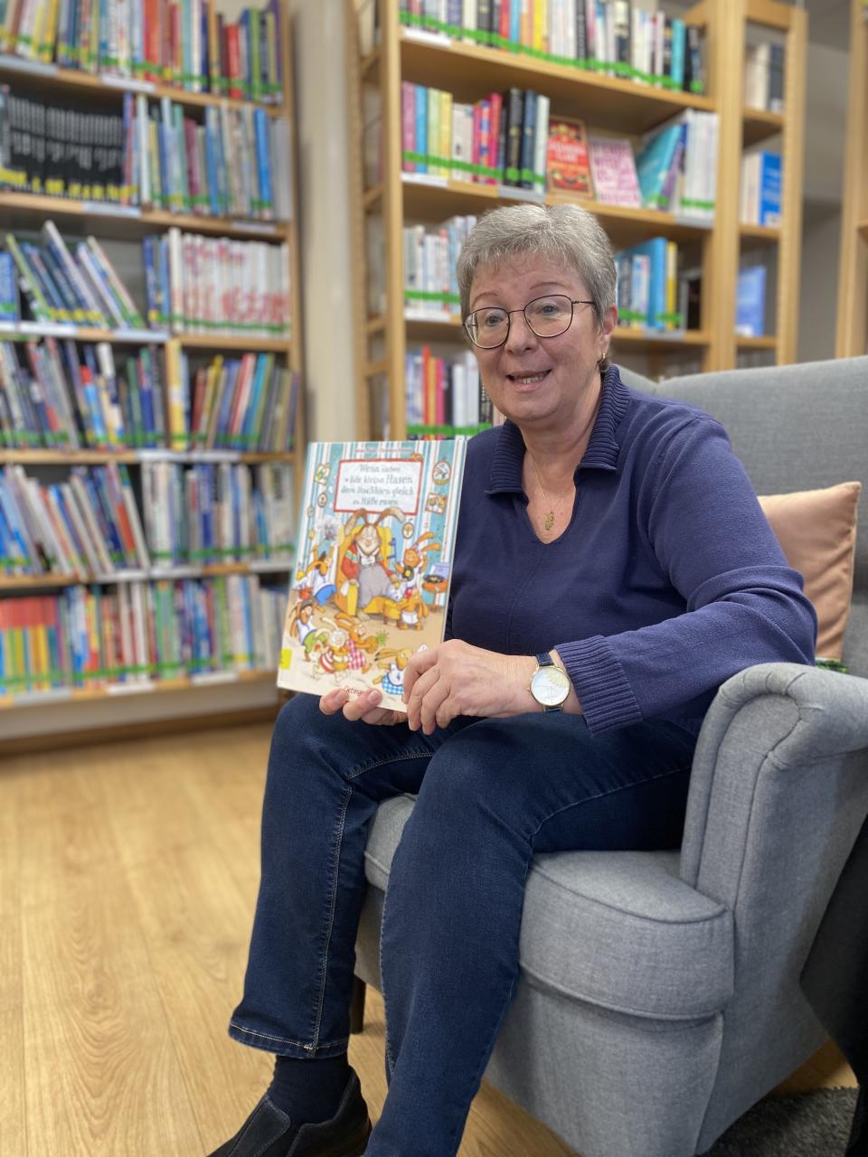 Eine Frau zeigt ein Buch vor