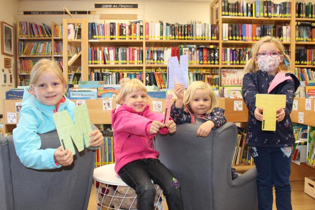 Vier Kinder halten die Buchstaben MINT in der Hand