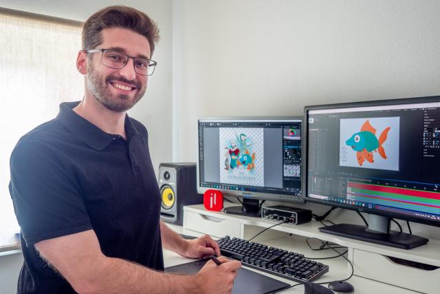 Ein Mann steht vor zwei Bildschirmen