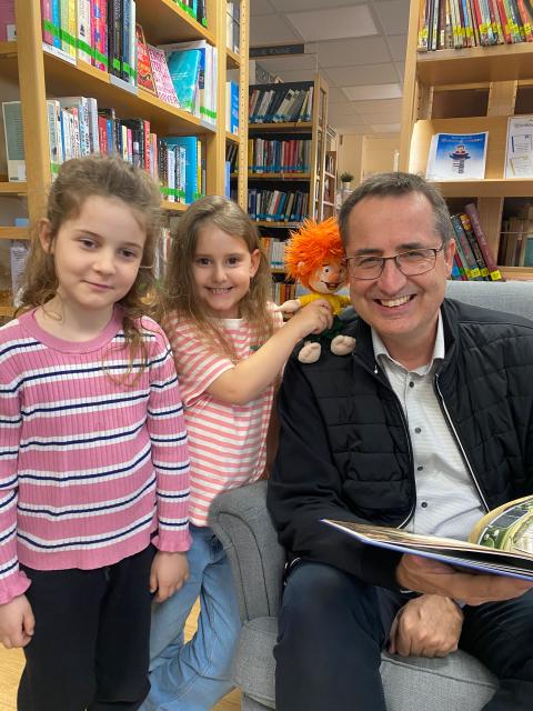 zwei Mädchen mit dem Bürgermeister und einer Stoffpuppe