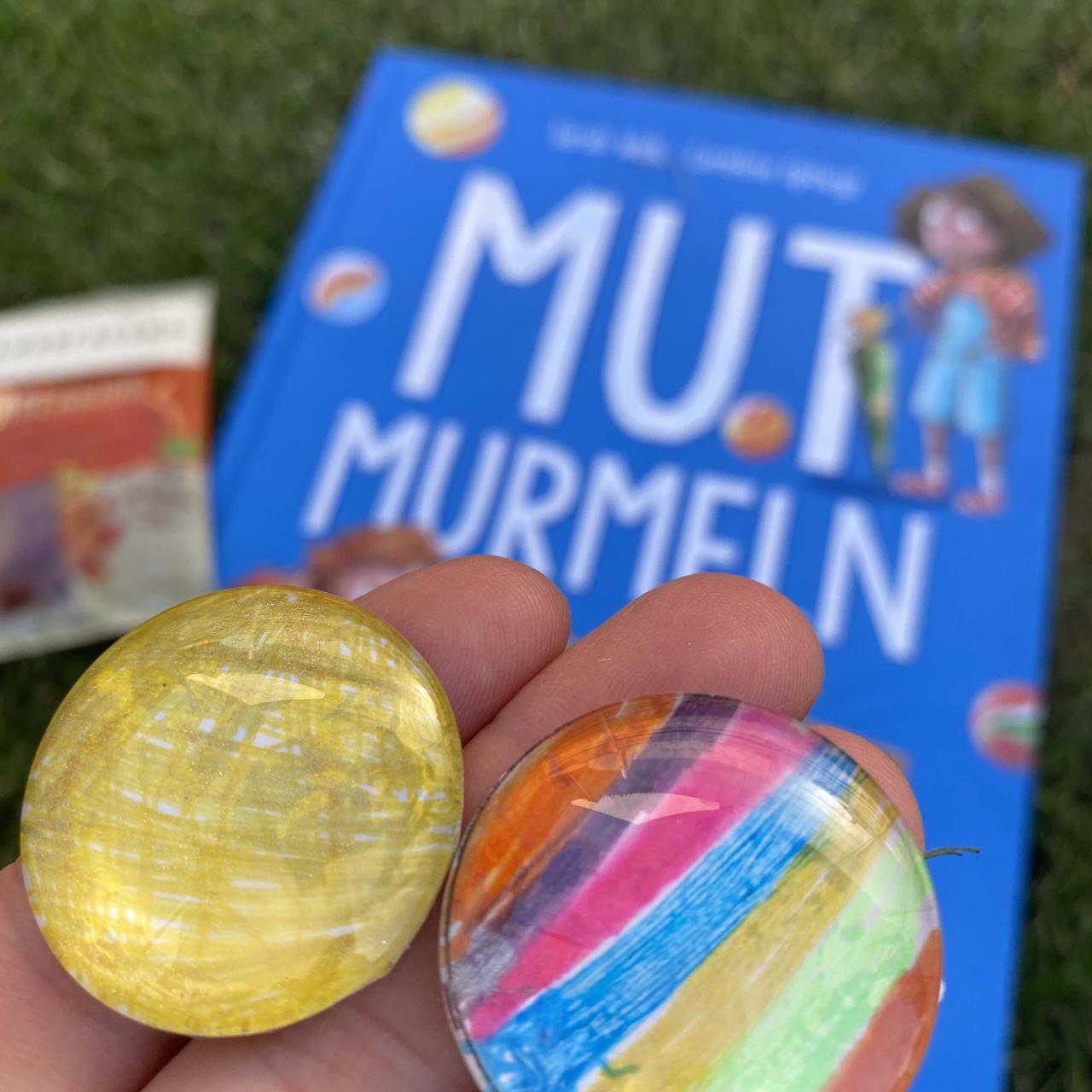 Zwei Glassteine die bunt bemalt sind