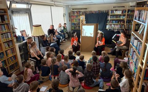 Kinder sitzen am Boden uns verfolgen das Schattentheater der Aiserkids