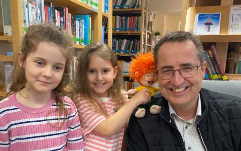 zwei Mädchen mit dem Bürgermeister und einer Stoffpuppe